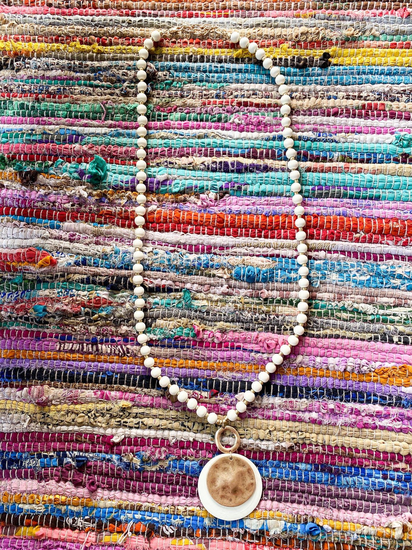 Long  beaded with circular metal pendant necklace